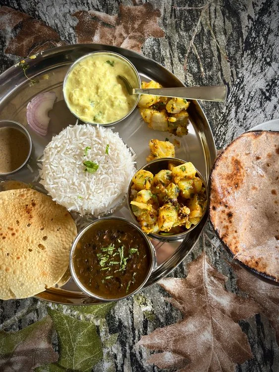 Traditional Indian vegetarian thali with half the plate covered in non-starchy vegetables, one quarter protein and one quarter grain