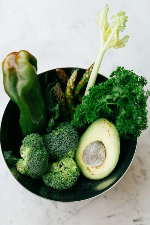 Fresh green leafy vegetables including spinach and bitter gourd — non-starchy vegetables ideal for people managing blood sugar