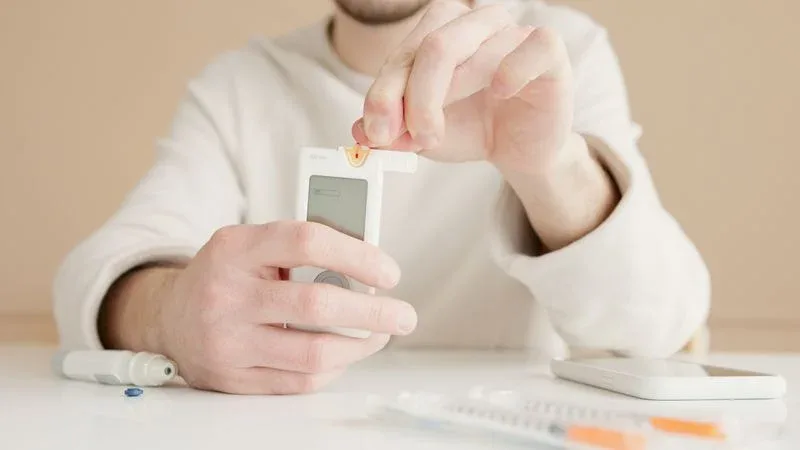 Person using a blood glucose meter – clinical trials show pomegranate reduces fasting blood glucose in people with diabetes