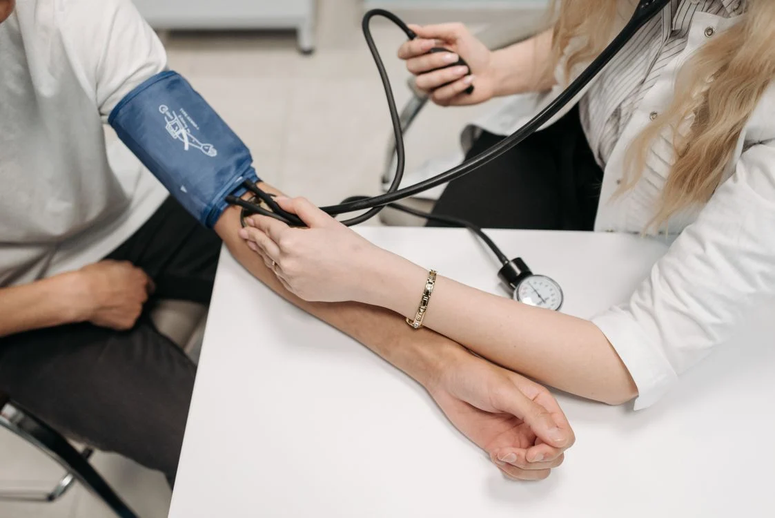 A doctor discusses diabetes management options with a patient sitting across a desk in a clinic