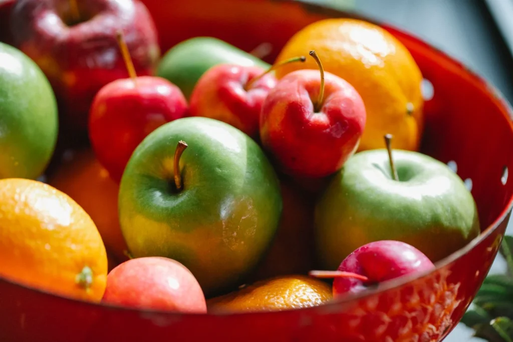 Colorful assortment of apples, oranges and mandarins in a bowl for comparing fruits suitable for diabetes