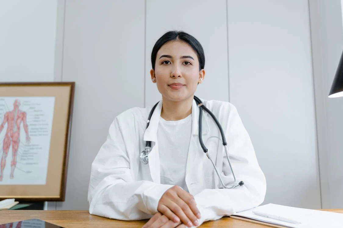 A nutritionist holds a clipboard and reviews a healthy meal plan with a patient in a clinical setting