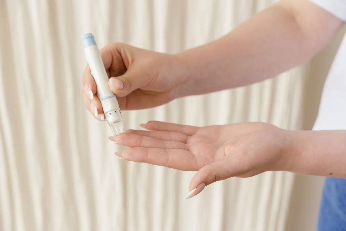 Person using a glucometer to test blood sugar levels at home