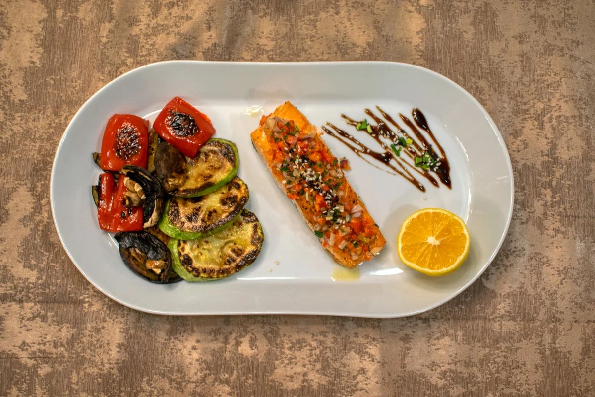 Grilled fish and fresh vegetables on a white plate demonstrating the diabetes plate method proportions