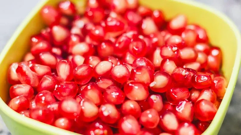 Half-cup of pomegranate arils in a white bowl – the recommended daily portion for people with diabetes