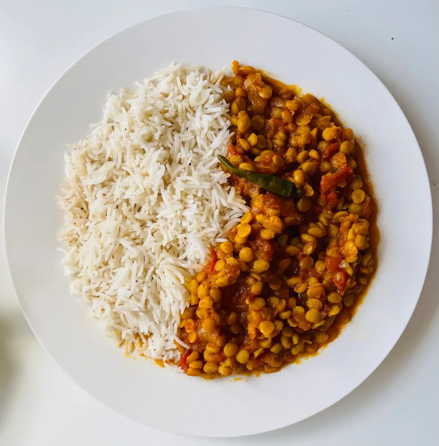 Rice and lentil curry served on a white plate.