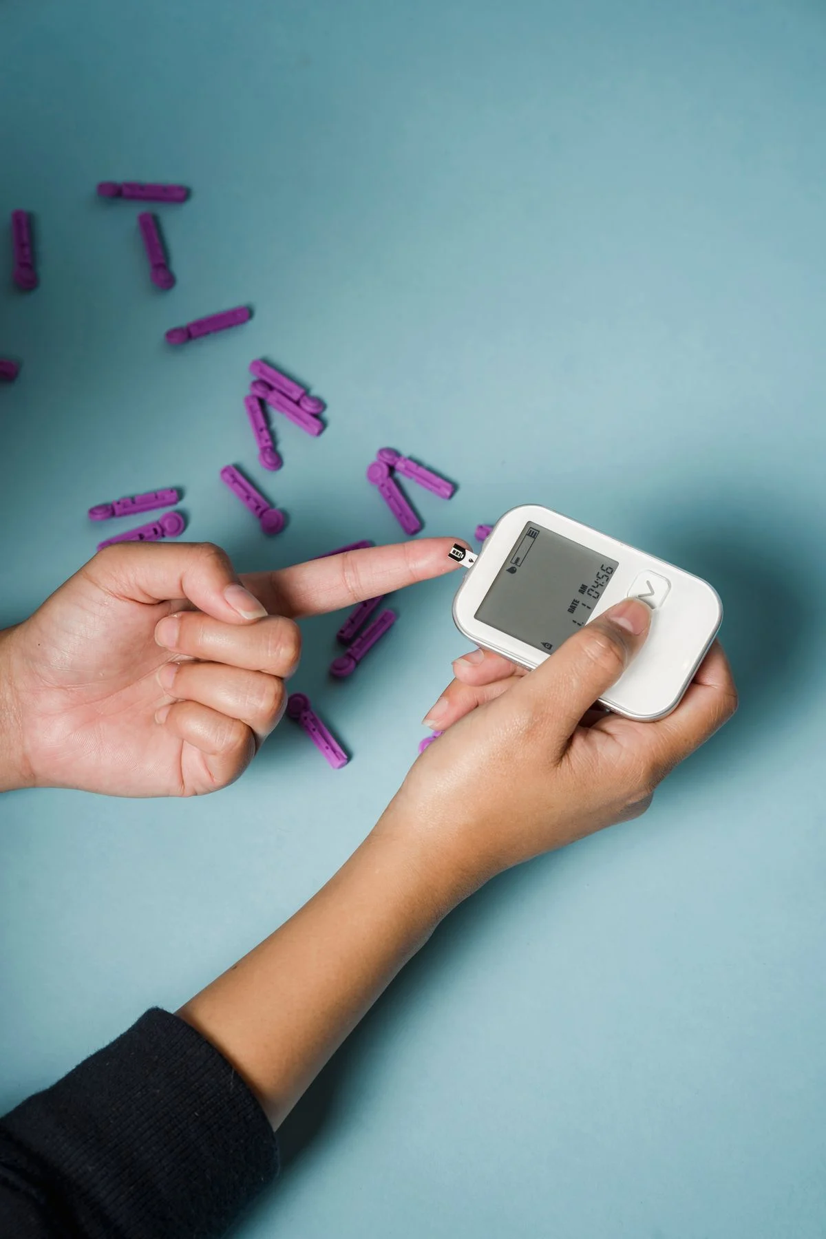 Woman checking her blood sugar levels with a glucometer at home